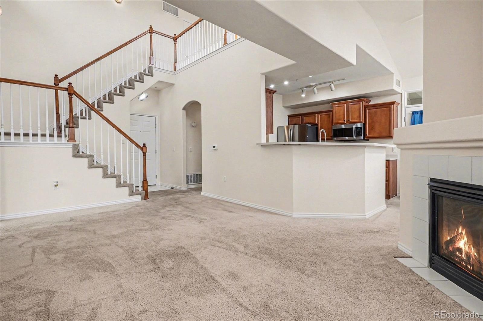 18611 Stroh Road, Unit 5208 Parker, CO 80134 - Photo 5 of 27 a view of an empty room with stairs and a fireplace