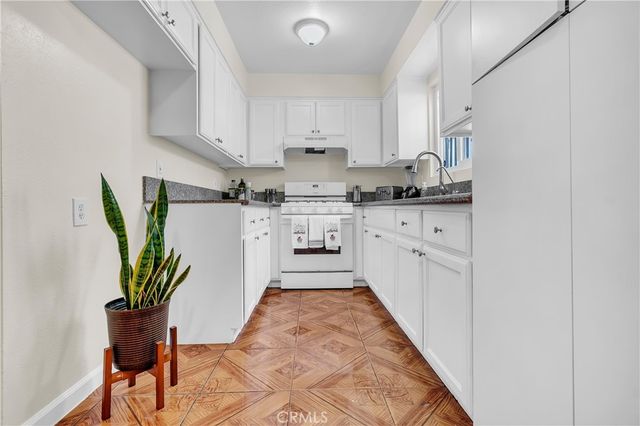 a kitchen with stainless steel appliances granite countertop a sink a stove and cabinets