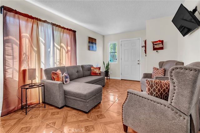 a living room with furniture a flat screen tv and a window