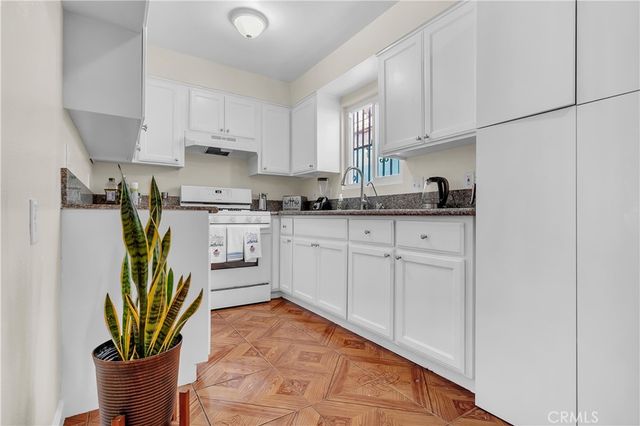 a kitchen with stainless steel appliances granite countertop a sink a stove and cabinets