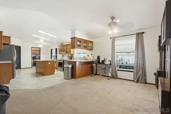 a view of a kitchen with refrigerator and windows