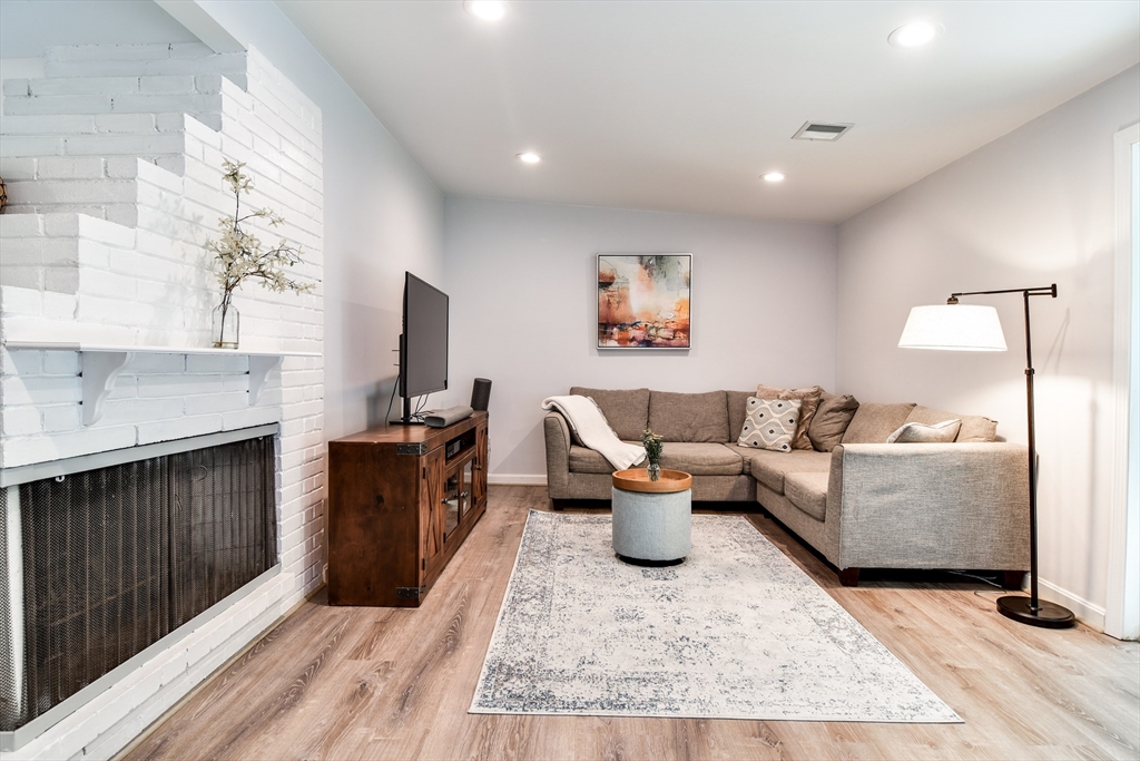10 Ruth Drive Framingham, MA 01701 - Photo 5 of 28 a living room with furniture a fireplace and a flat screen tv
