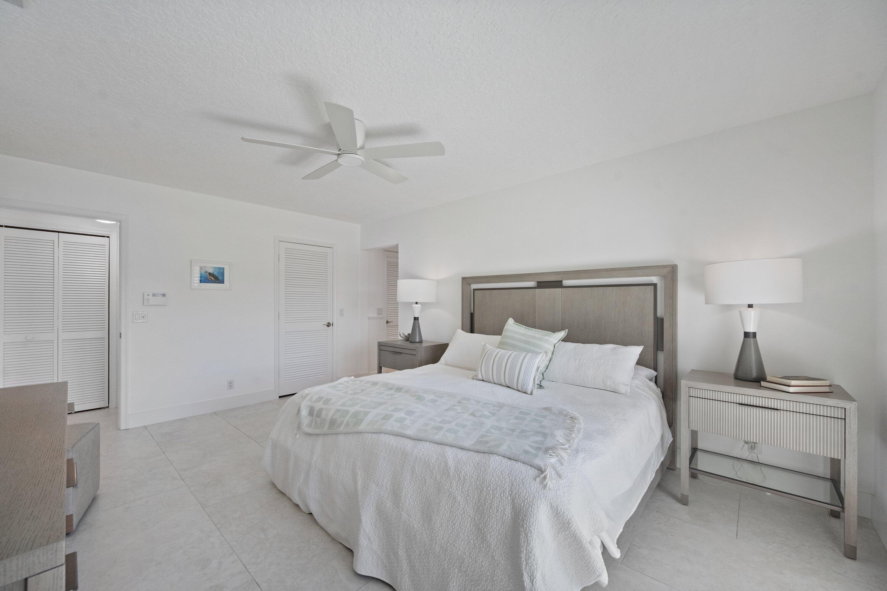 3940 Back Bay Drive, Unit 241 Jupiter, FL 33477 - Photo 13 of 19 a bedroom with a bed and a ceiling fan