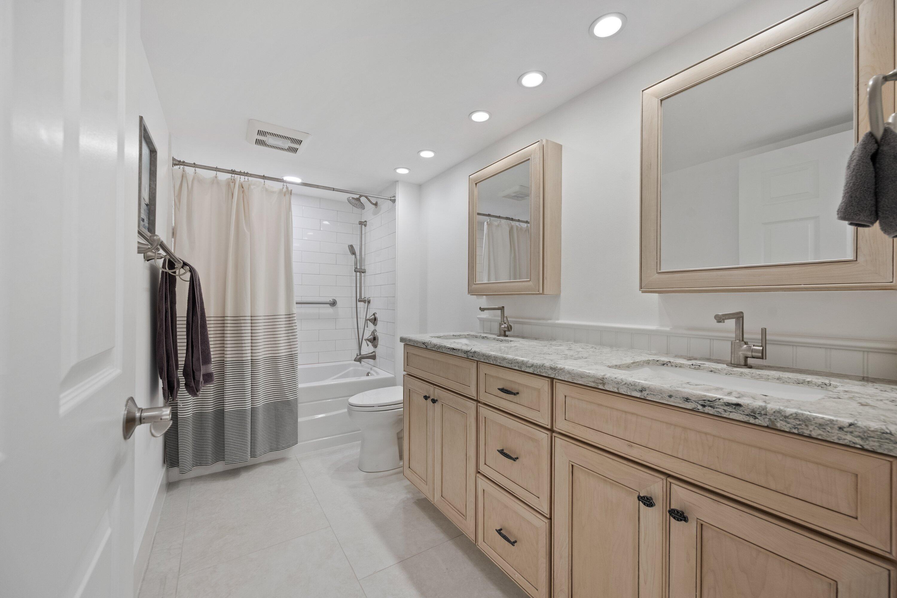 3940 Back Bay Drive, Unit 241 Jupiter, FL 33477 - Photo 16 of 19 a bathroom with a granite countertop sink mirror and a shower