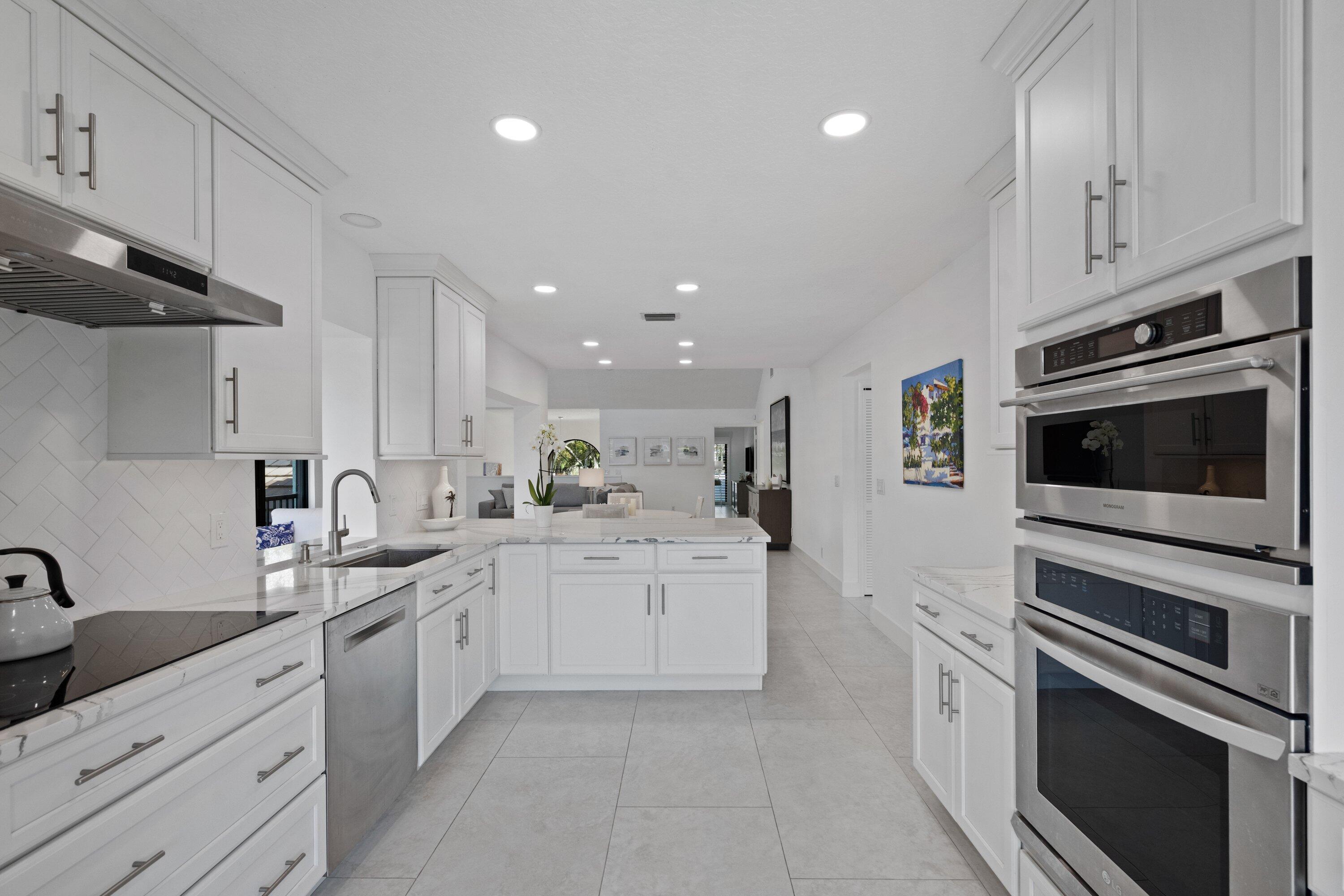 3940 Back Bay Drive, Unit 241 Jupiter, FL 33477 - Photo 8 of 19 a kitchen with a sink stainless steel appliances and cabinets