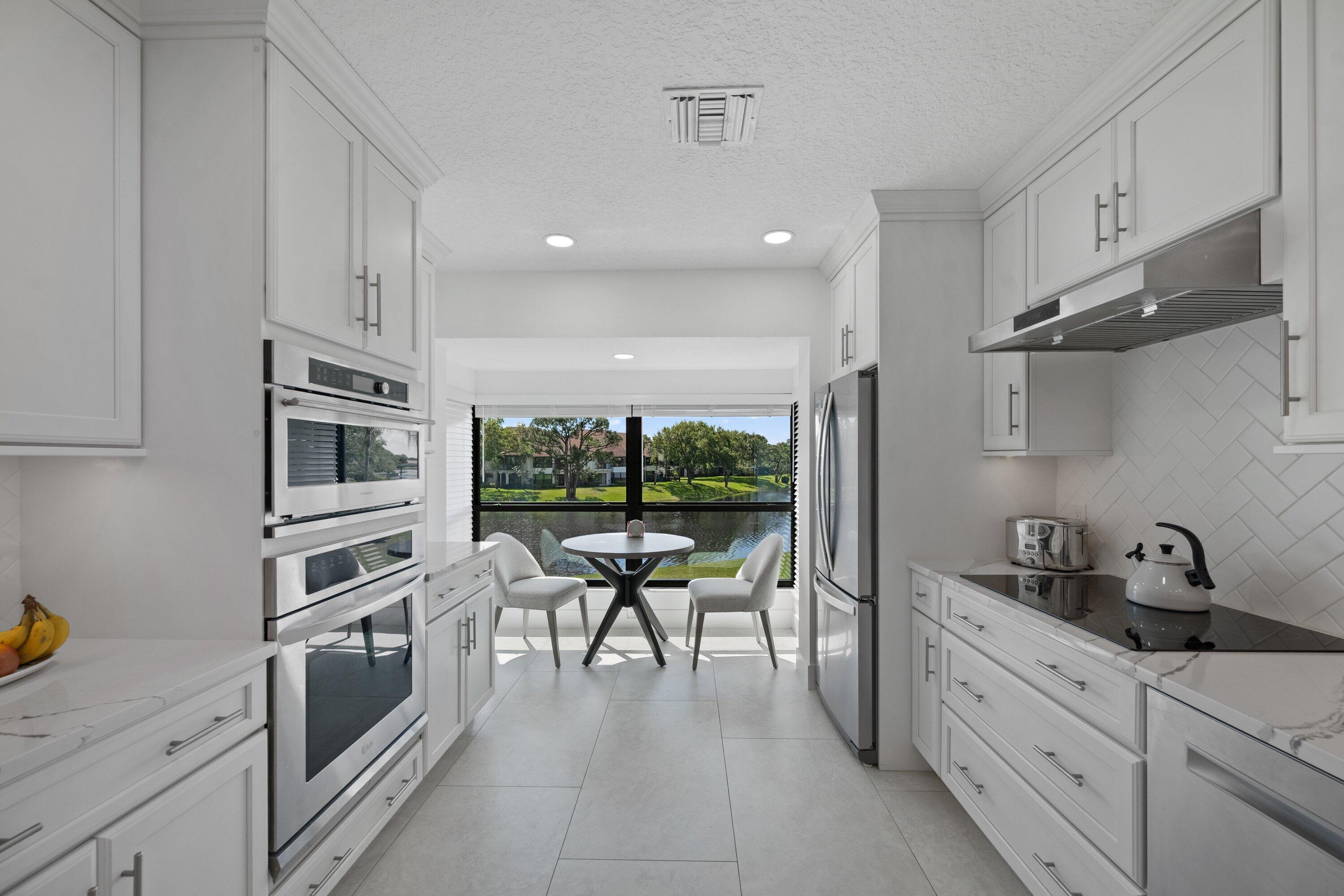 3940 Back Bay Drive, Unit 241 Jupiter, FL 33477 - Photo 9 of 19 a kitchen with granite countertop a stove a sink and a refrigerator