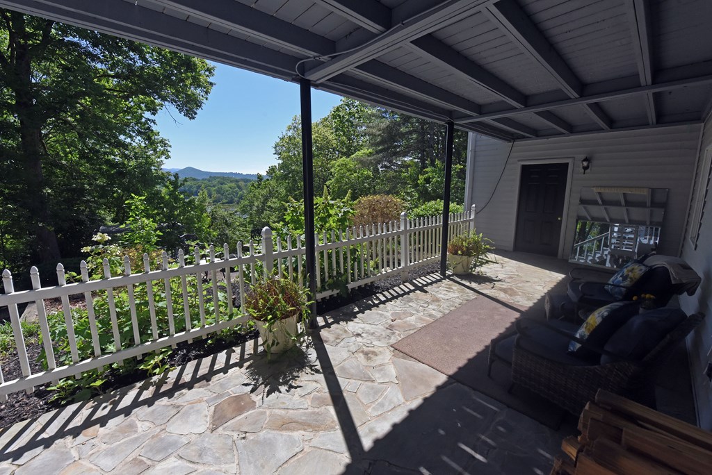 382 Pat Colwell Road Blairsville, GA 30512 - Photo 40 of 42 a view of a patio with table and chairs potted plants with floor to ceiling window and wooden fence