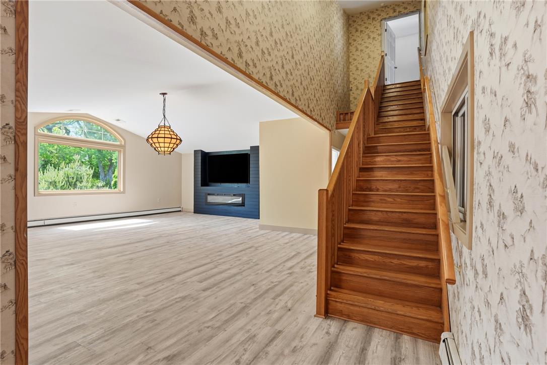 6271 Batman Road Zionsville, PA 18092 - Photo 29 of 100 A spacious living area awaits, featuring high ceilings, a grand arched window, and a built-in media center with a fireplace.