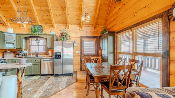 a dining room with furniture and large windows