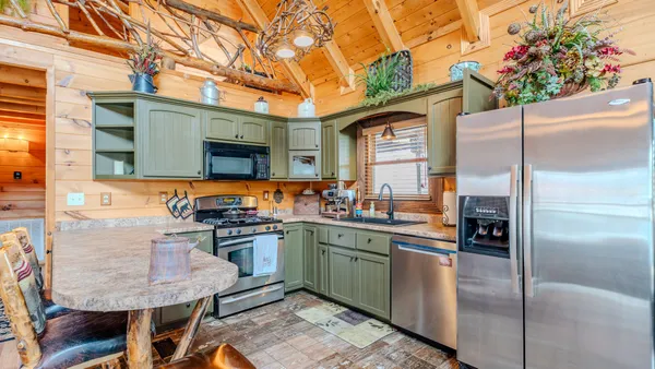 a kitchen with stainless steel appliances granite countertop a sink a stove and cabinets