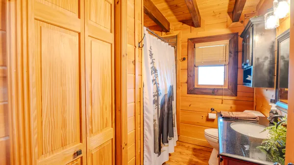 a view of hallway with wooden floor and a window