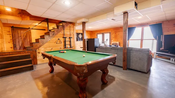 a room with pool table and windows