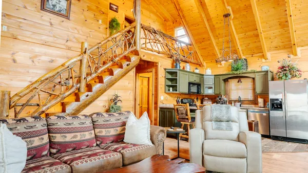 a living room with furniture a floor to ceiling windows and a flat screen tv