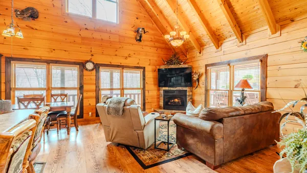 a living room with furniture a fireplace and a floor to ceiling window