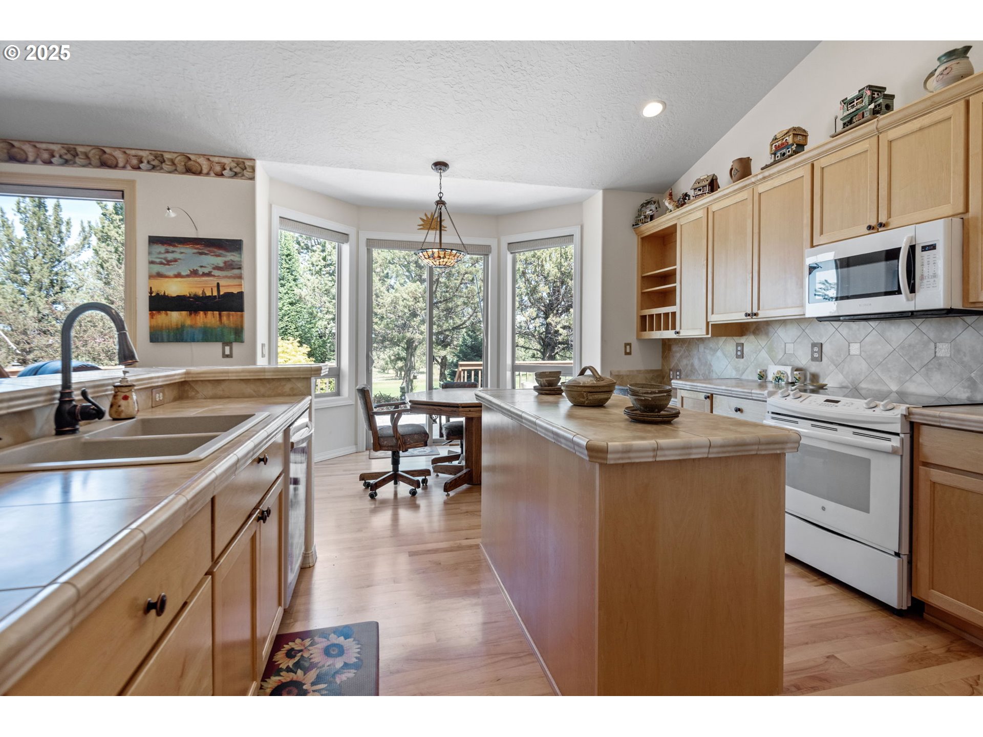 454 Tanager Drive Redmond, OR 97756 - Photo 11 of 31 a kitchen with kitchen island granite countertop a sink stove and cabinets