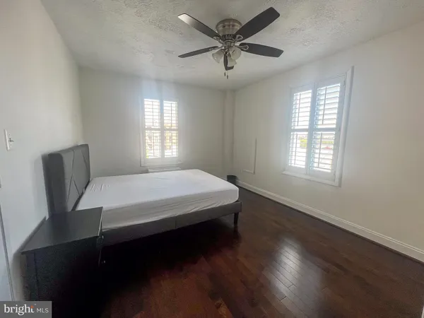 a bed sitting in a spacious bedroom next to a window