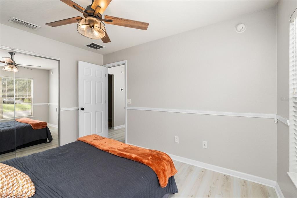 4098 Southwest 47th Court Ocala, FL 34474 - Photo 22 of 44 a bedroom with a bed and a chandelier