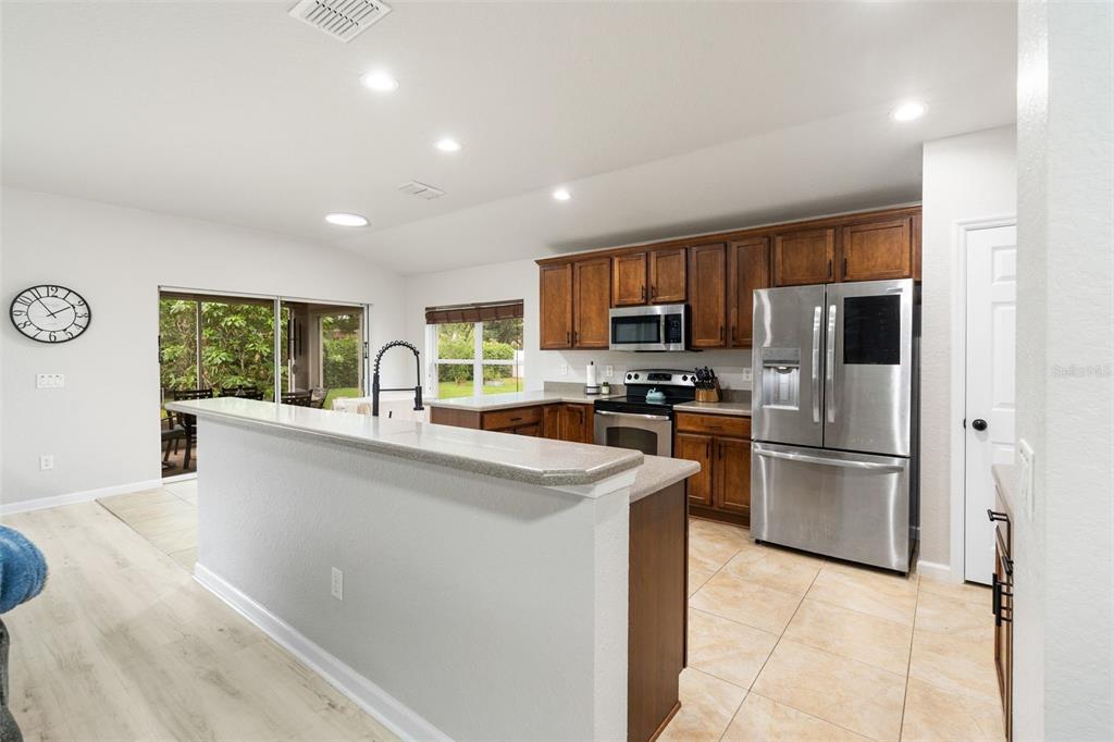 4098 Southwest 47th Court Ocala, FL 34474 - Photo 9 of 44 a kitchen with kitchen island a refrigerator sink stove and oven