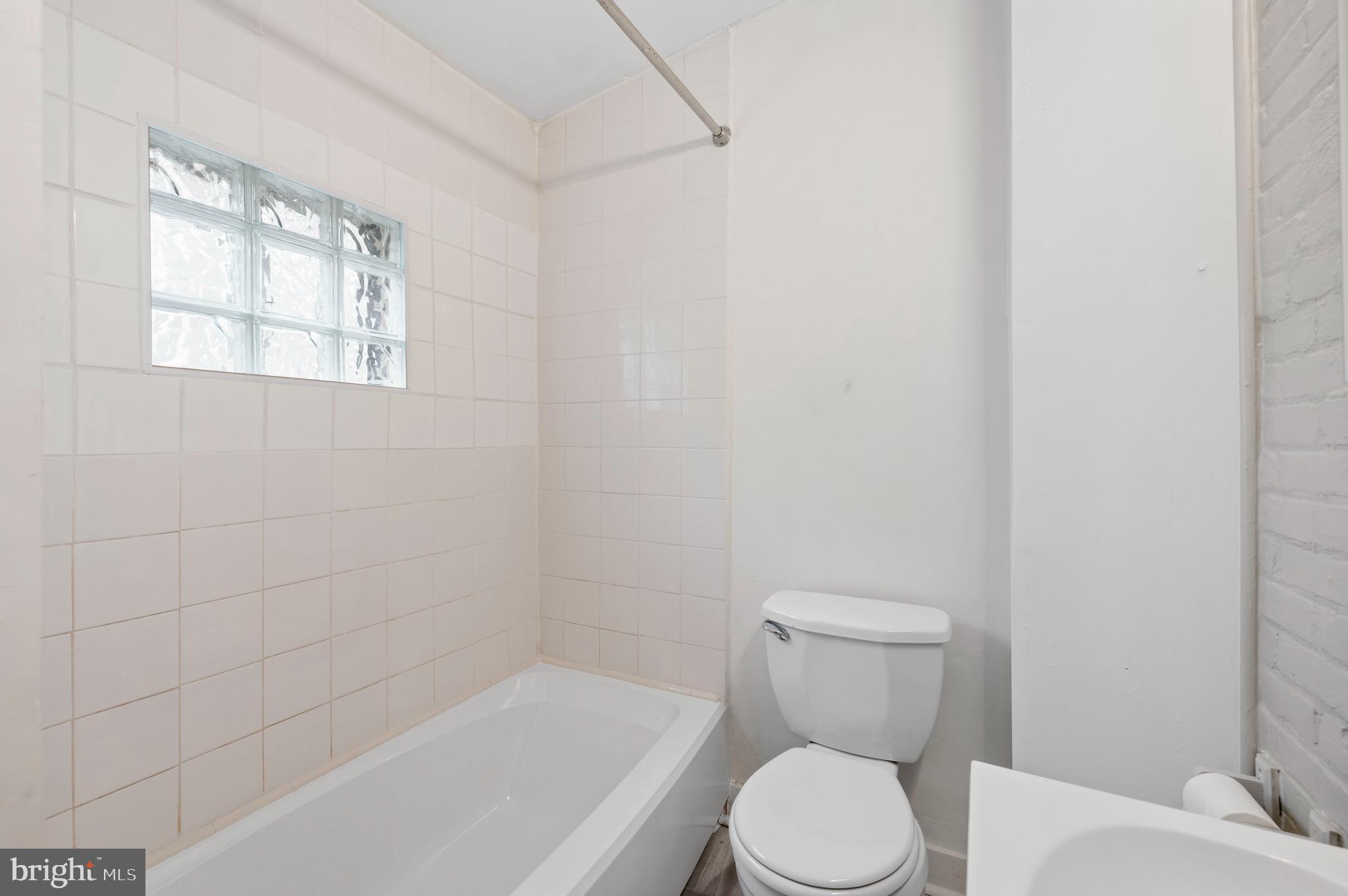 2304 Catharine Street, Unit 1 Philadelphia, PA 19146 - Photo 12 of 14 a white toilet sitting next to a bath tub