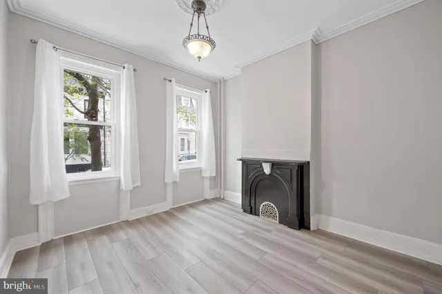 a view of a livingroom with wooden floor a fireplace and windows