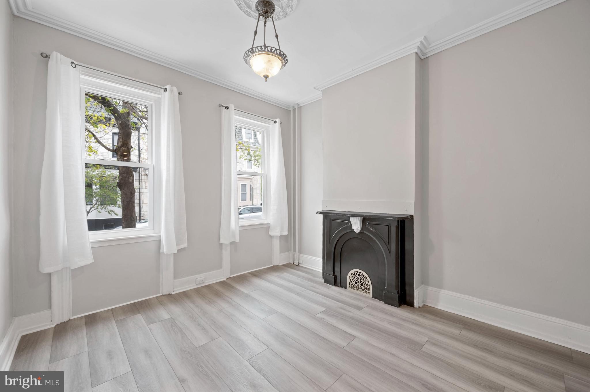 2304 Catharine Street, Unit 1 Philadelphia, PA 19146 - Photo 5 of 14 a view of a livingroom with wooden floor a fireplace and windows