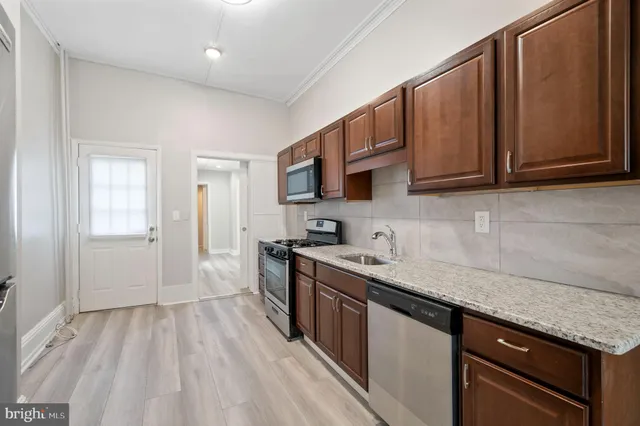 a kitchen with stainless steel appliances granite countertop a sink stove and microwave