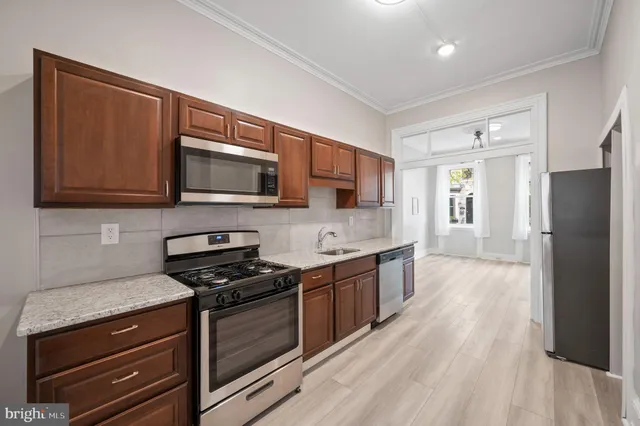 a kitchen with stainless steel appliances a stove microwave and cabinets
