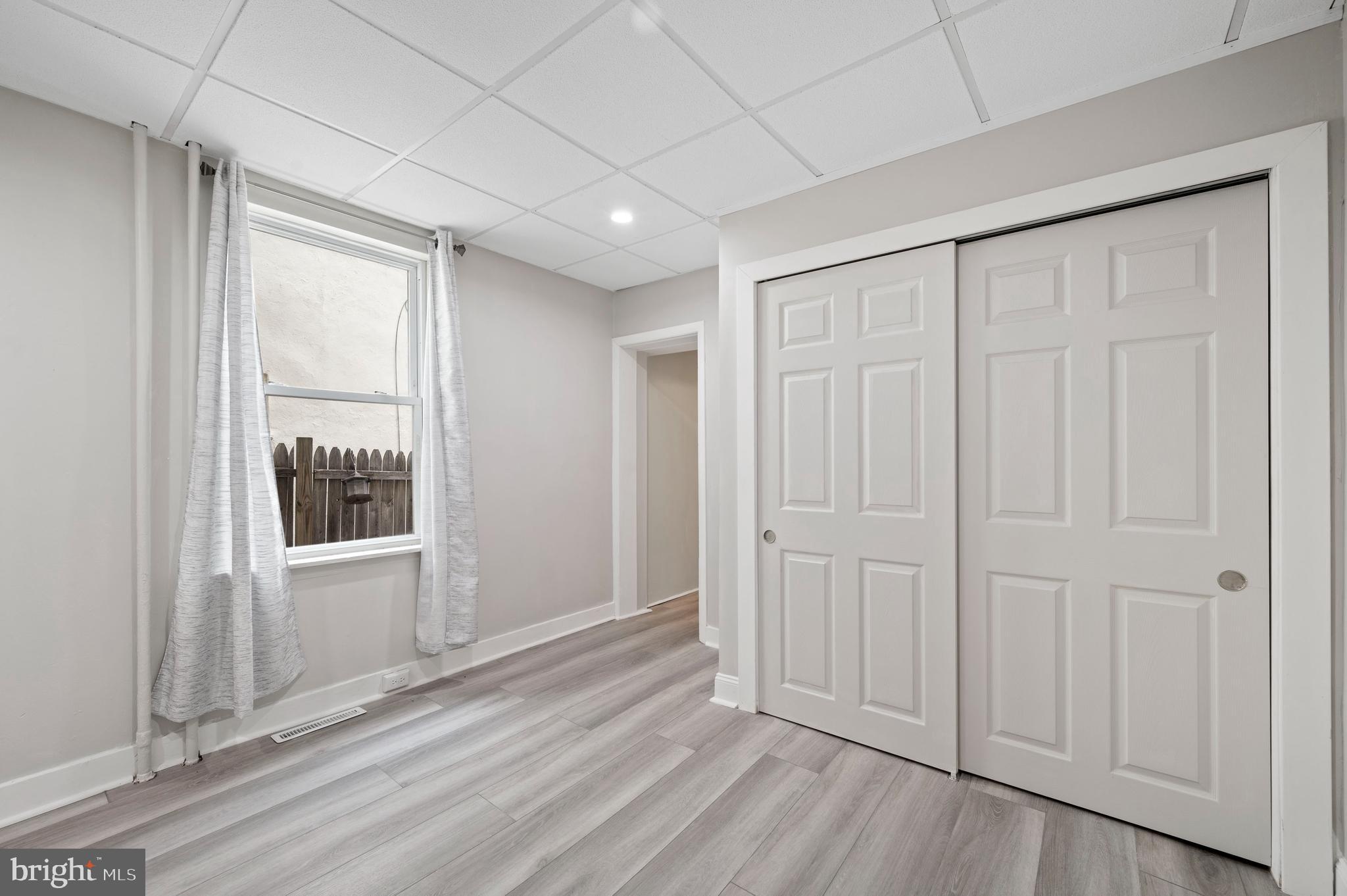 2304 Catharine Street, Unit 1 Philadelphia, PA 19146 - Photo 9 of 14 an empty room with wooden floor and windows