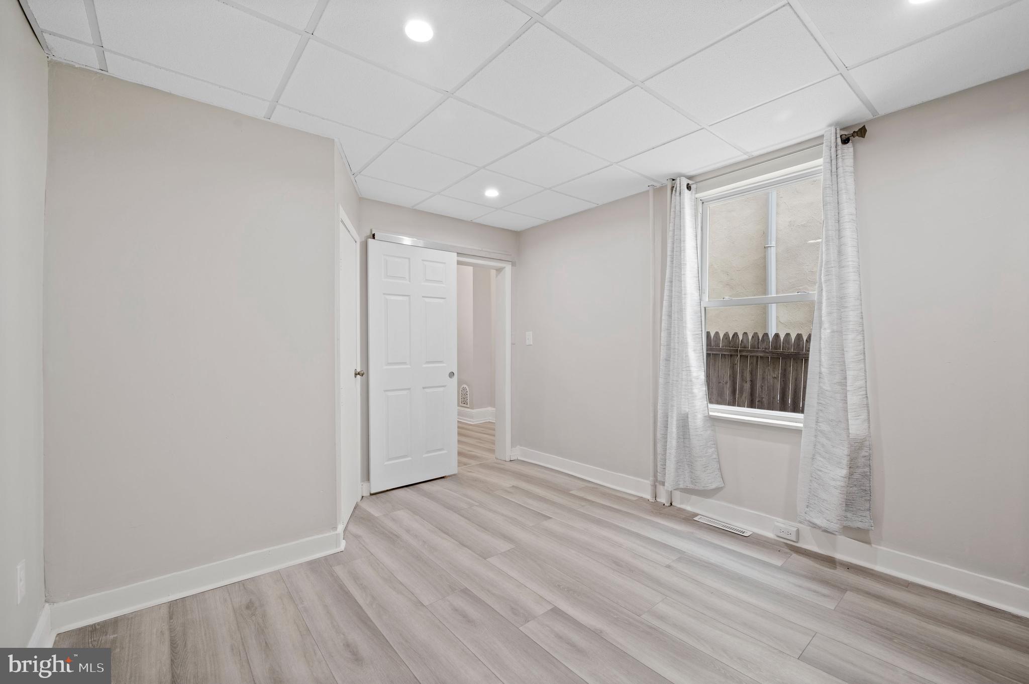 2304 Catharine Street, Unit 1 Philadelphia, PA 19146 - Photo 10 of 14 an empty room with wooden floor and windows