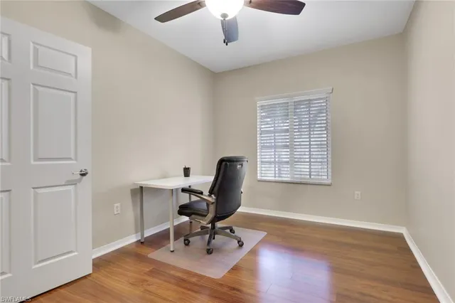 a view of a workspace with furniture and a window
