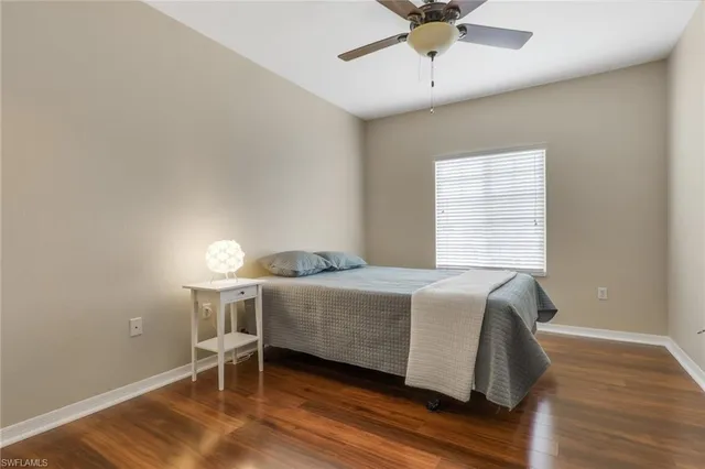 a bed sitting in a bedroom next to a window and a chair