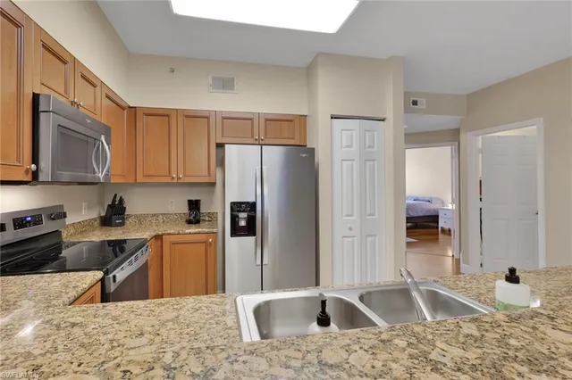 a kitchen with a refrigerator sink and cabinets