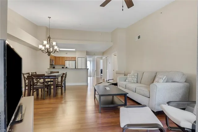 a living room with furniture a dining table and a chandelier