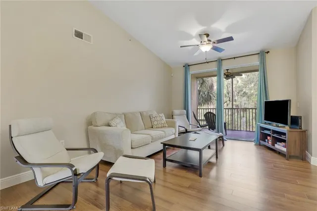 a living room with furniture a flat screen tv and wooden floor
