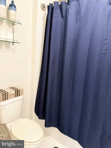 a white toilet sitting next to a wooden vanity