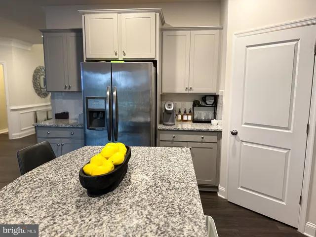 a kitchen with stainless steel appliances kitchen island granite countertop a refrigerator a stove a microwave and cabinets