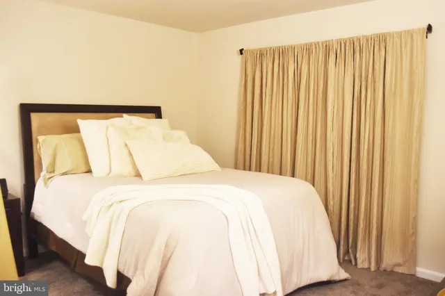 a large bed sitting in a bedroom next to a window