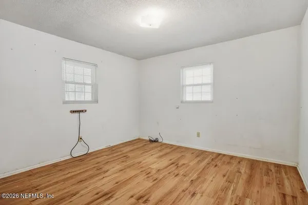 a view of empty room with wooden floor