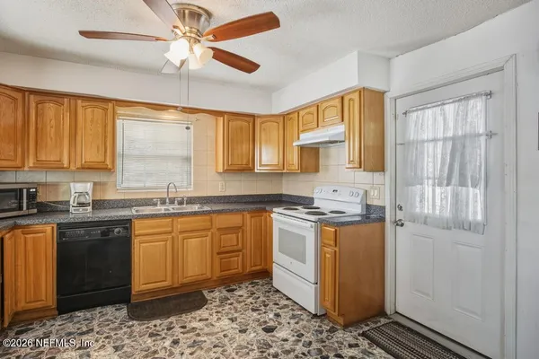 a kitchen with stainless steel appliances granite countertop a stove sink and cabinets