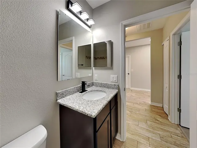 a bathroom with a granite countertop sink and a mirror