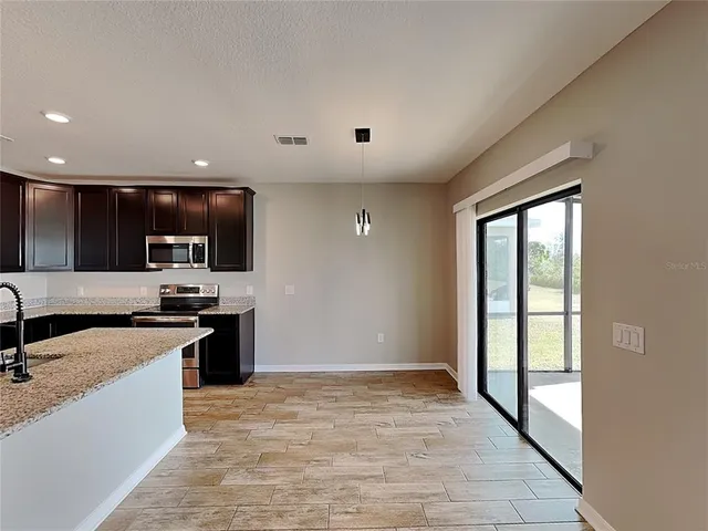 a large kitchen with stainless steel appliances granite countertop a large stove a sink and a microwave