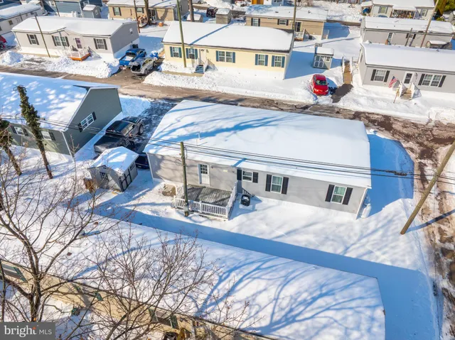 a front view of a house with a yard covered in snow