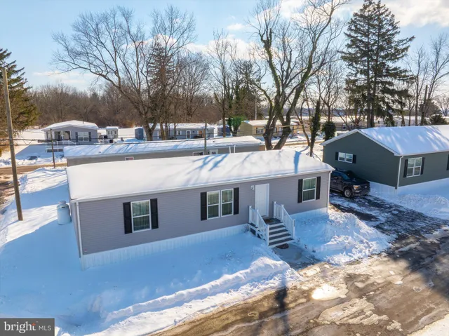 a view of a house with a yard covered with snow in the background