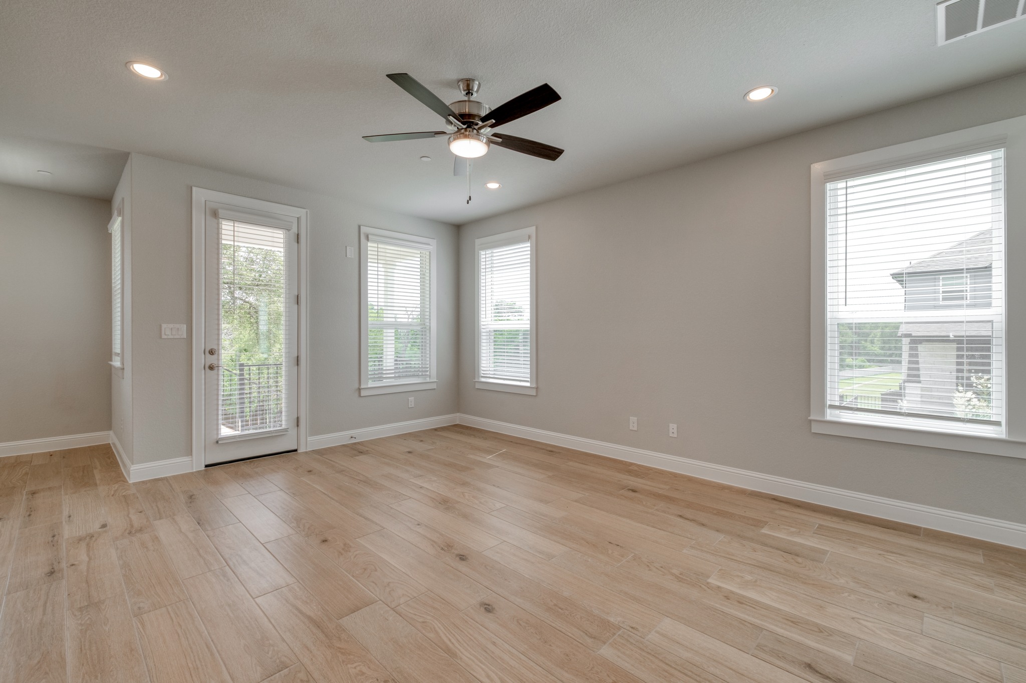 2605 Sam Bass Road, Unit 44 Round Rock, TX 78681 - Photo 6 of 26 Blonde wood flooring anchors this versatile space, featuring a door to the outdoors and multiple windows.
