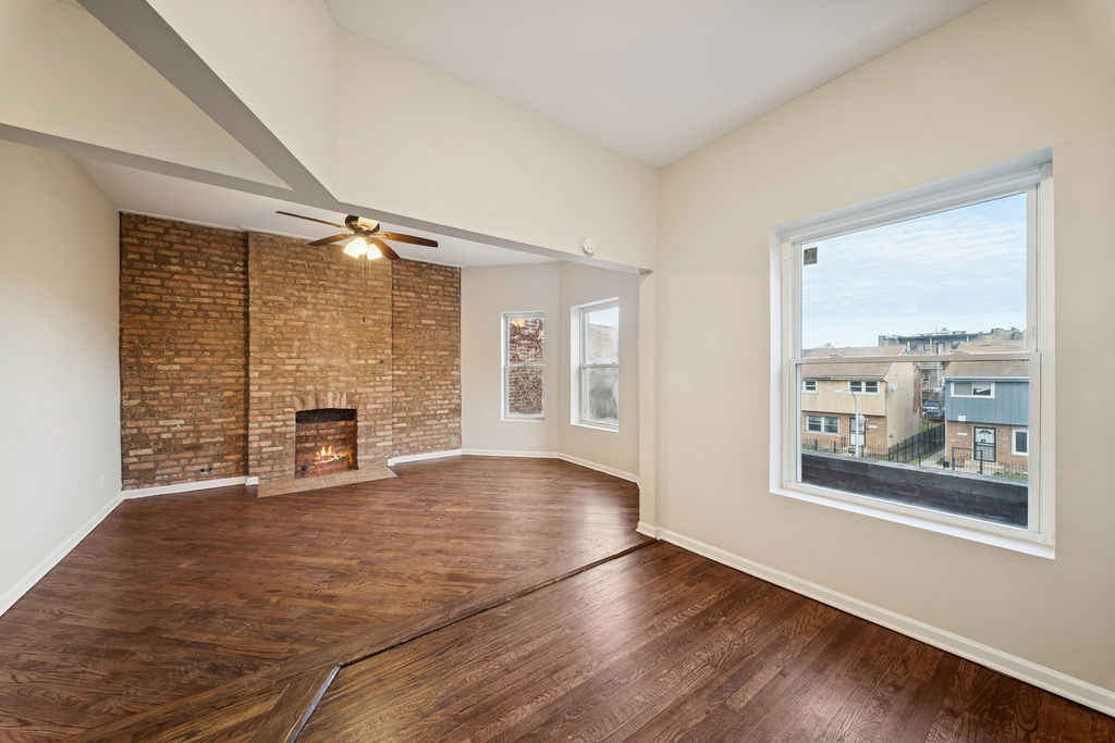 6520 South Ellis Avenue Chicago, IL 60637 - Photo 13 of 38 a view of an empty room with a fireplace and a window