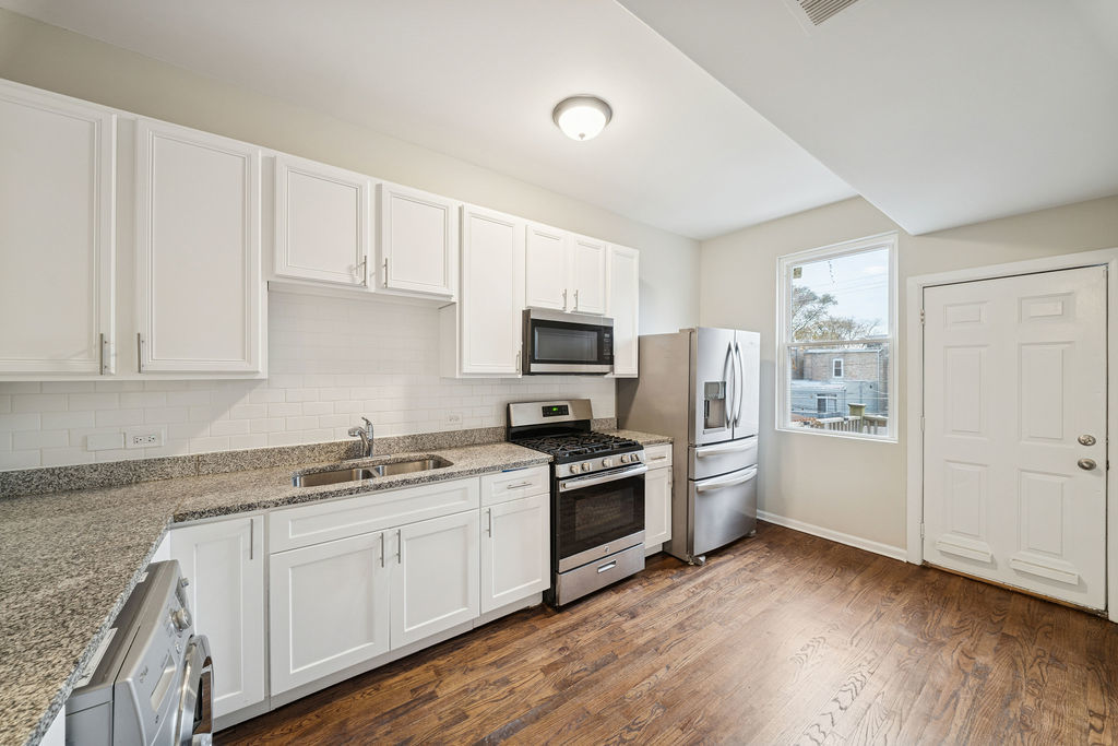 6520 South Ellis Avenue Chicago, IL 60637 - Photo 19 of 38 a kitchen with granite countertop white cabinets and stainless steel appliances