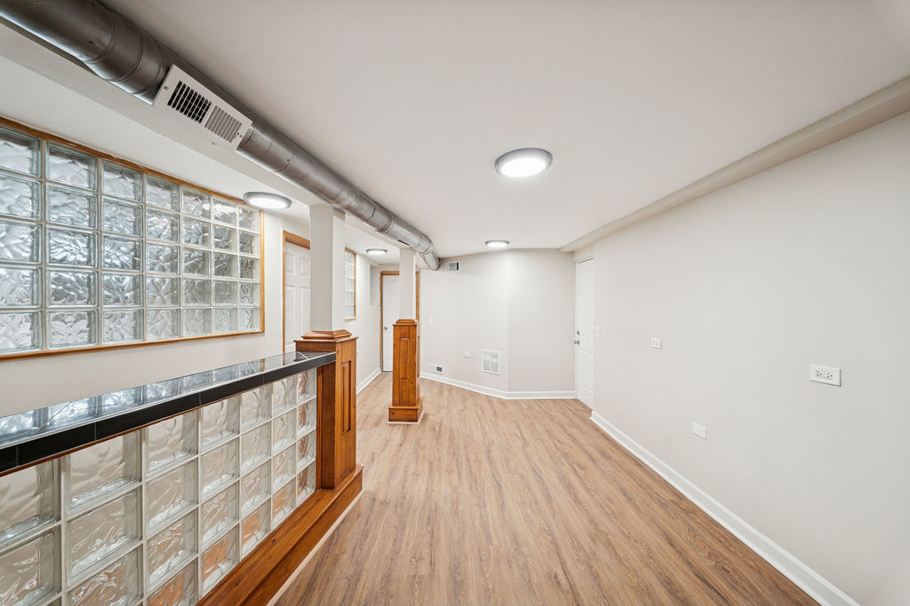 6520 South Ellis Avenue Chicago, IL 60637 - Photo 23 of 38 a view of an empty room with wooden floor and a window