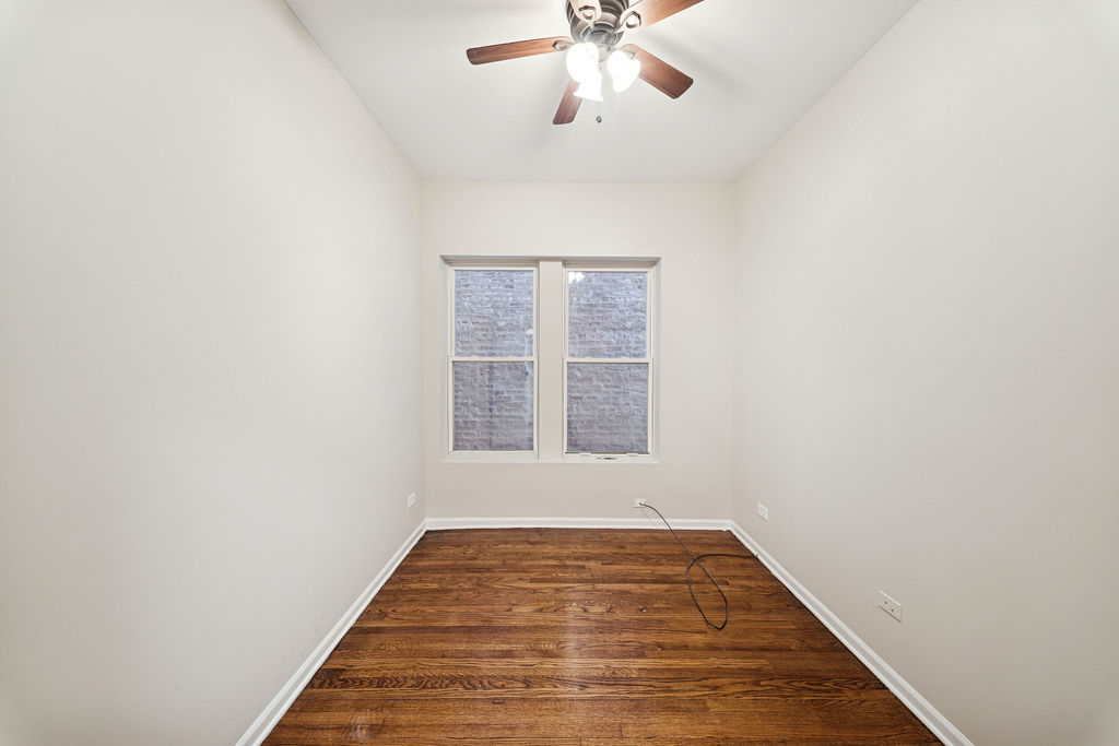 6520 South Ellis Avenue Chicago, IL 60637 - Photo 8 of 38 an empty room with wooden floor fan and windows