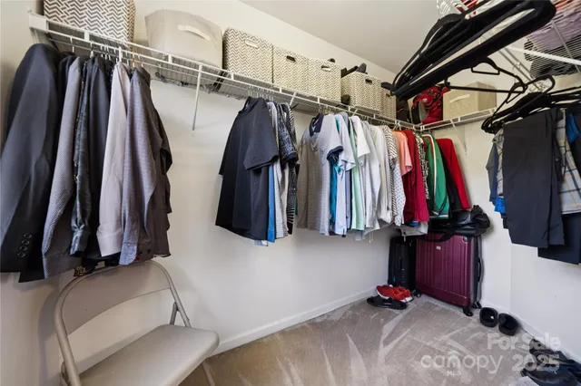 a view of walk in closet with clothes and shoes