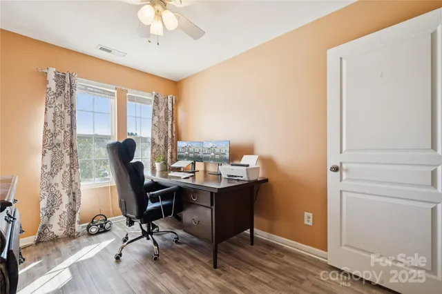 a view of a workspace with furniture and a window